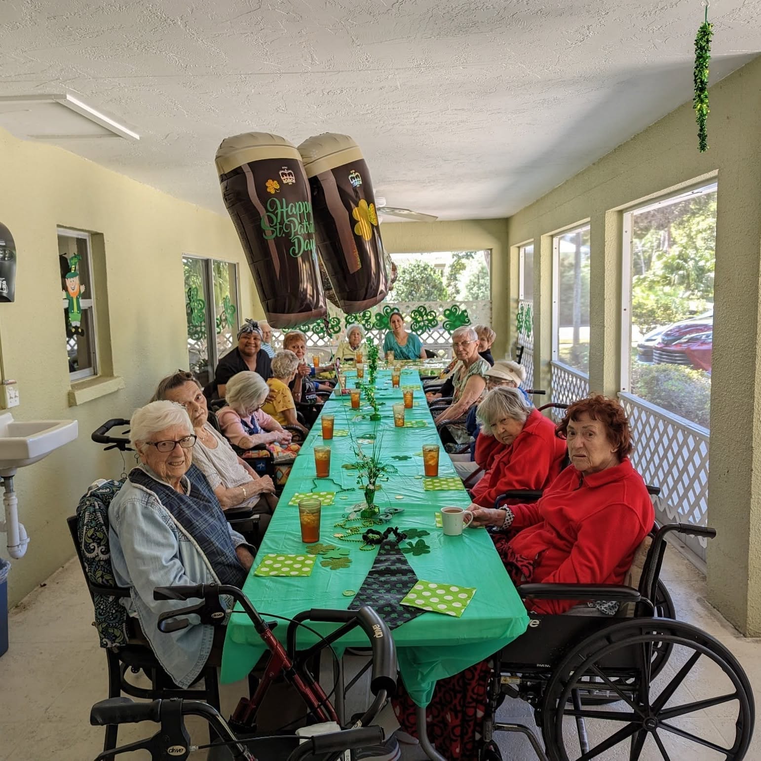 Residents enjoying a St. Patrick's Day celebration on the covered porch