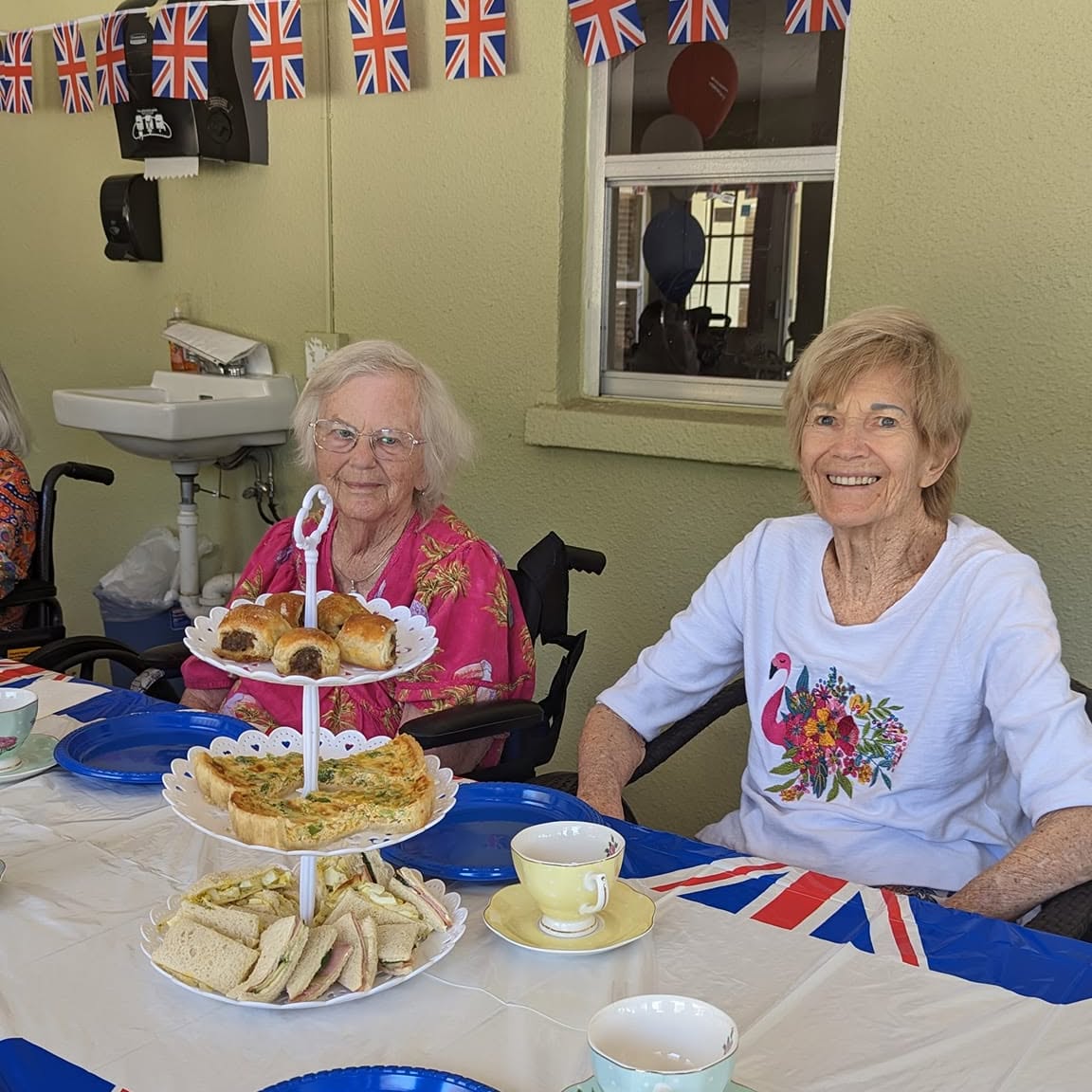 Smiling residents at a British-themed tea party